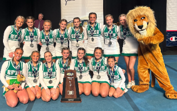 The SFHS competitive cheer team with their second place trophy at the state championships with the Lion mascot